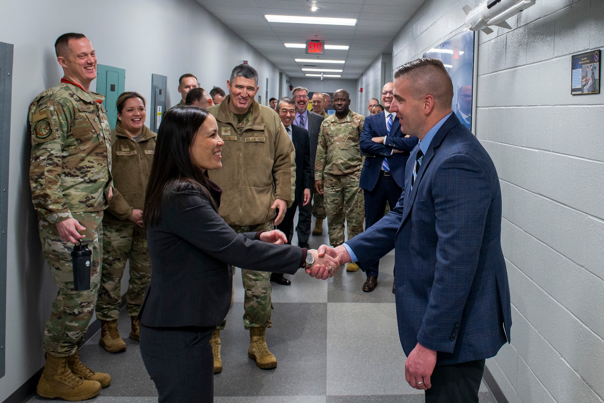 Under Secretary of the Air Force Gina Ortiz Jones presents a coin to Justin Hughes, an analyst from the Foreign Materiel Exploitation Squadron, during a tour of the National Air and Space Intelligence Center’s FME building, Wright-Patterson Air Force Base, Ohio, Jan. 9, 2023. In addition to meeting Hughes and other outstanding performers, Jones also received several intelligence briefings during her visit.