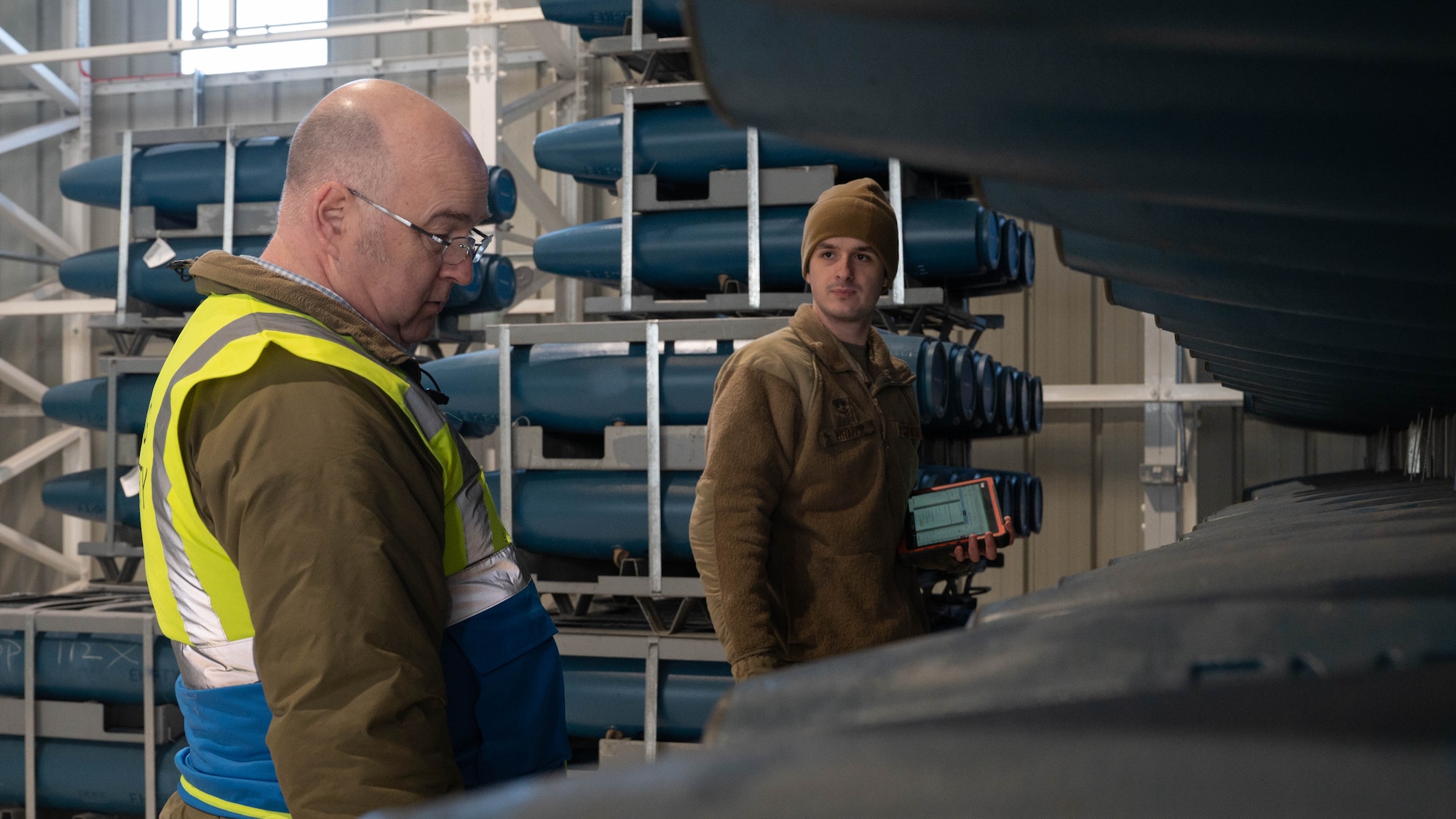 two men look at BDU-50's, training ordnances, in a warehouse at RAF Lakenheath, England