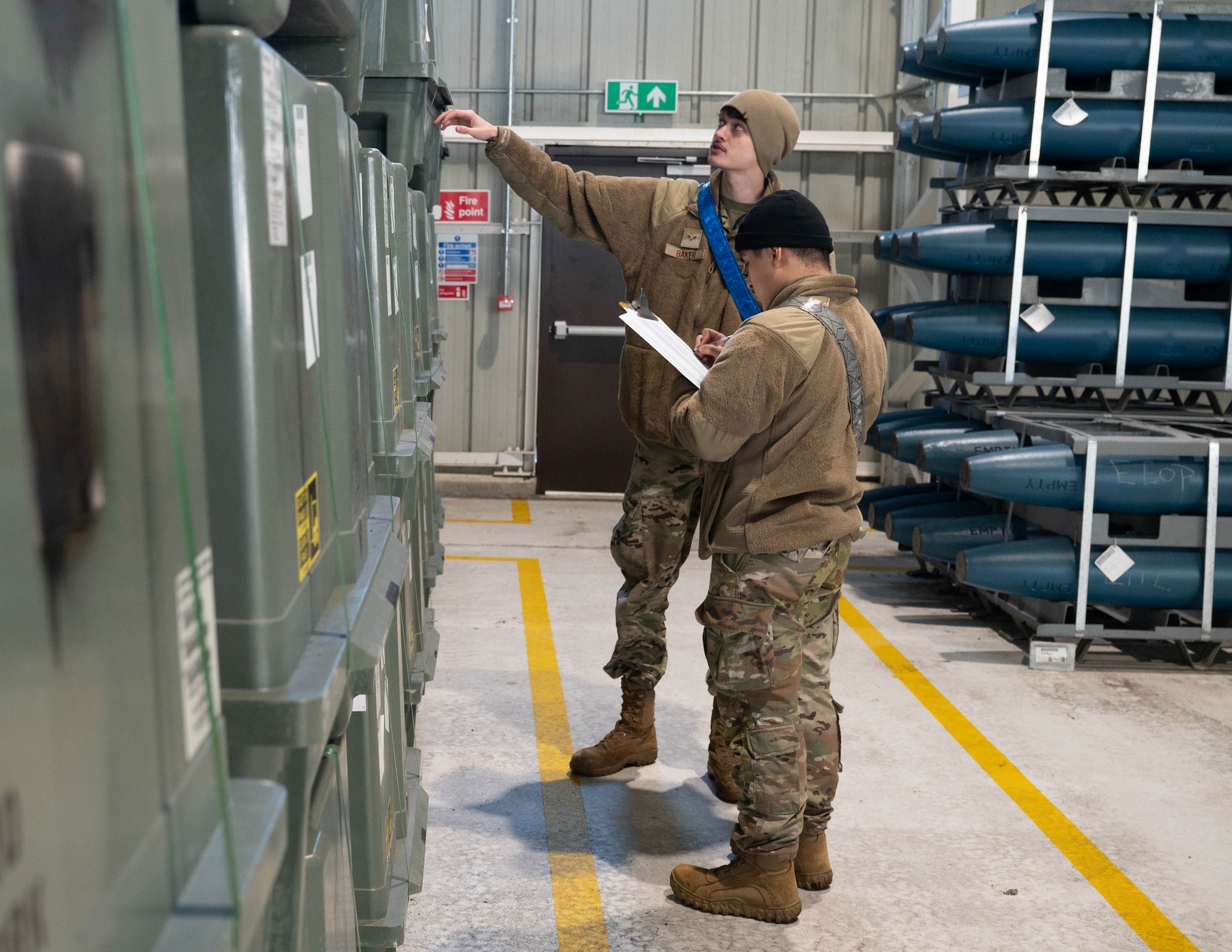 two men look at ordnance inventory in a warehouse at RAF Lakenheath, England