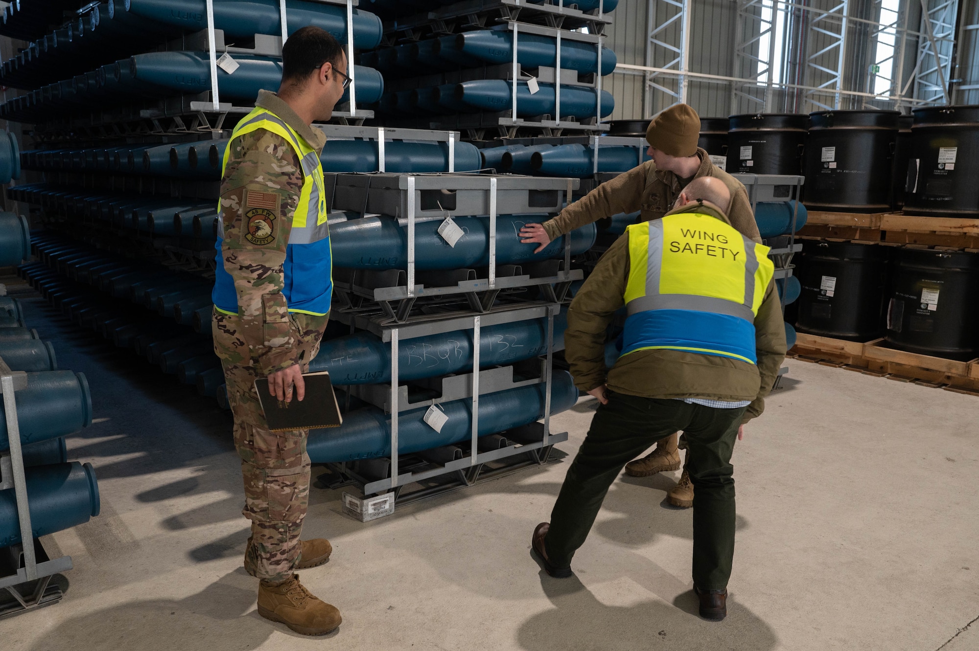 two men look at ordnances stored in a wearhouse at RAF Lakenheath, England