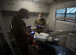 From left, Lt. Col. Christopher Fauver and Sgt. Katie Lindh of the NHARNG Medical Detachment prepare Samuel Chilel for a filling in a mobile dental clinic Jan. 7 at the Beech Street Elementary School in Manchester.