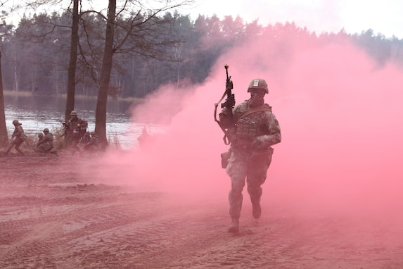 U.S. Army Second Squadron, Second Cavalry Regiment Troops emerge from the smoke ready to fight and secure a landing zone after being transported in their Strykers across a lake by the Polish Army during Tumak 20 Nov. 25, 2020, near Bemowo Piskie Training Area, Poland. (U.S. Army photo by Staff Sgt. Elizabeth O. Bryson