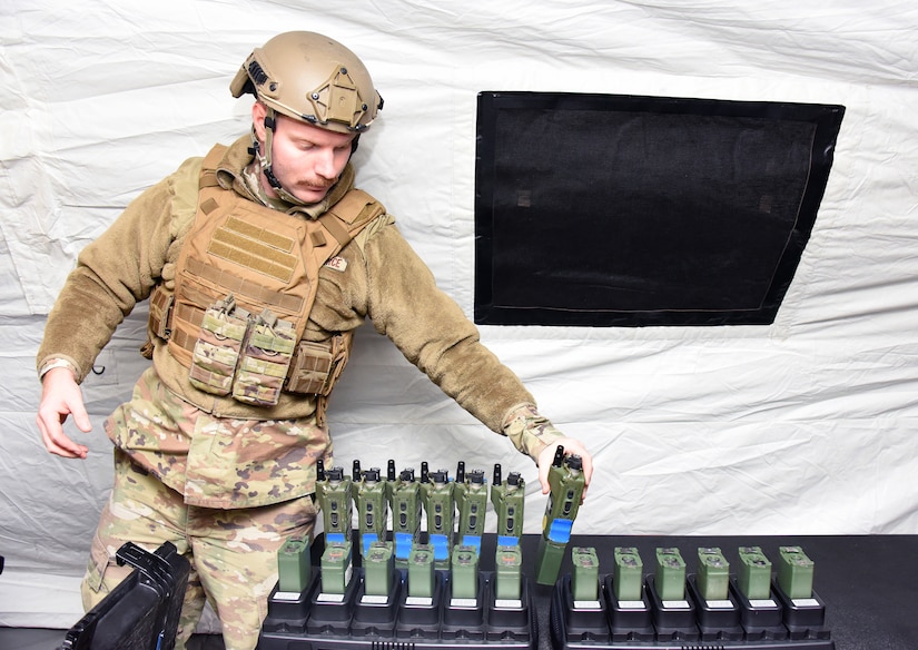 An airman from the 621st Contingency Response Squadron sets up handheld transceivers inside the tactical operations center, in preparation for the Jersey Devil 23 exercise.