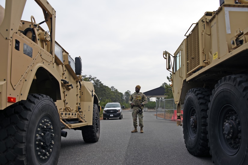U.S. Air Force Staff Sgt. Raymond Sylvester, 87th Security Forces Squadron patrolman, stands between a joint light tactical vehicle and a light equipment transporter, as he inspects both vehicles outside the U.S. Army Reserve National Guard entrance gate.