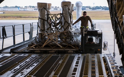 A photo of an Airman loading cargo on a C-17.
