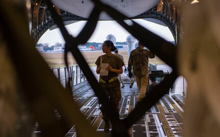 A photo of an Airman surveying cargo on a C-17.