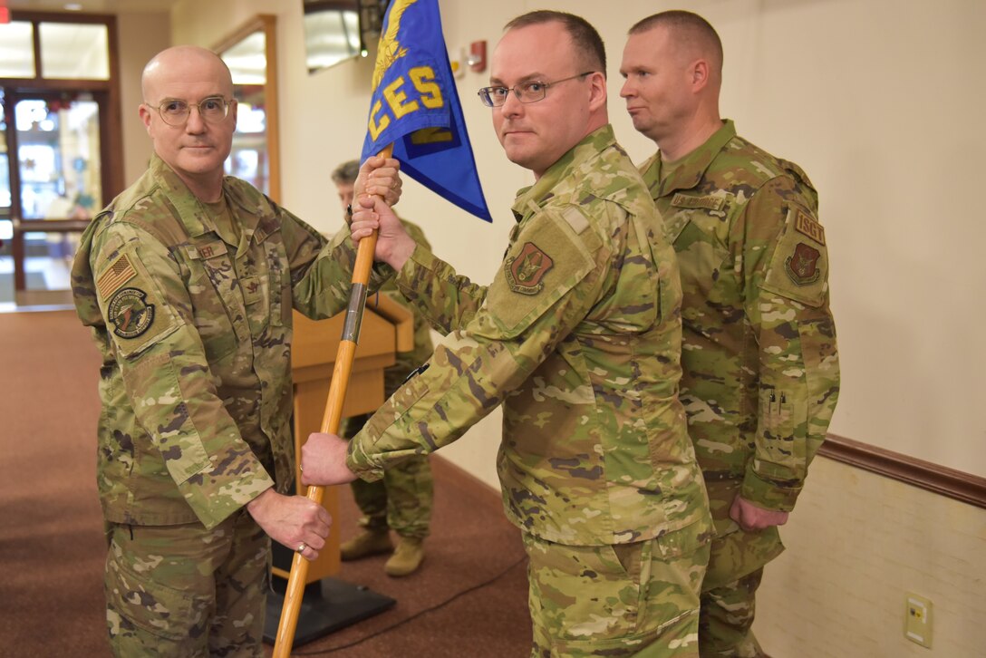 Lt Col Donald Harper (center) accepts the 914th Civil Engineer Squadron guidon flag, and thereby command of the squadron, from 914th Mission Support Group commander Col. Christopher Witter, as First Sergeant Timothy Connolly stands by Jan. 7, 2023 at Niagara Falls Air Reserve Station, New York.