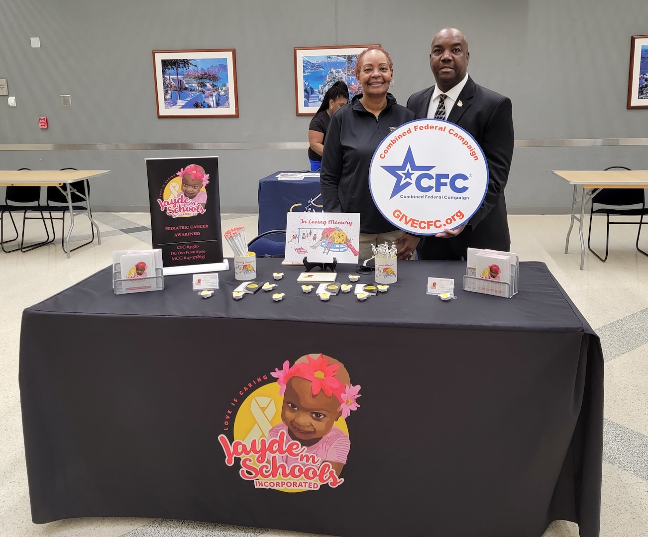 two people behind a table holding cfc logo