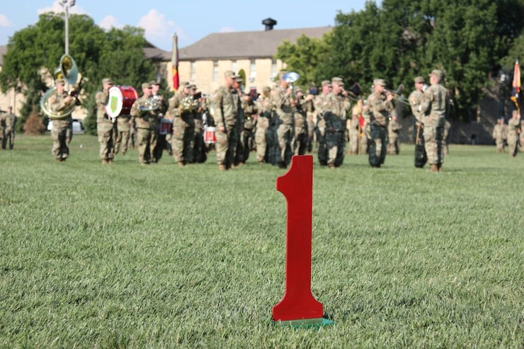 1ST INFANTRY DIVISION BAND playing in a field with a big red one in front of them.