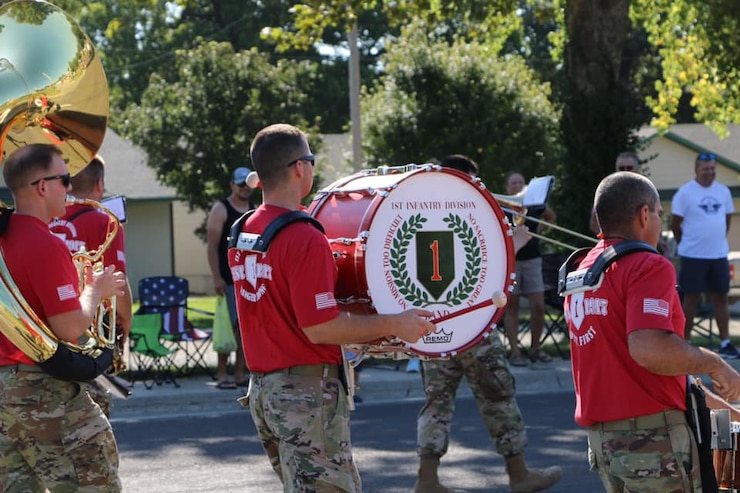 1ST INFANTRY DIVISION BAND marching with a drum with their logo displayed.