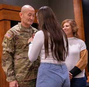 Asya Smith, daughter of newly promoted Col. Eric Smith, of Springfield, removes the lieutenant colonel rank on his uniform during a promotion ceremony Jan. 13 at Camp Lincoln, Springfield.