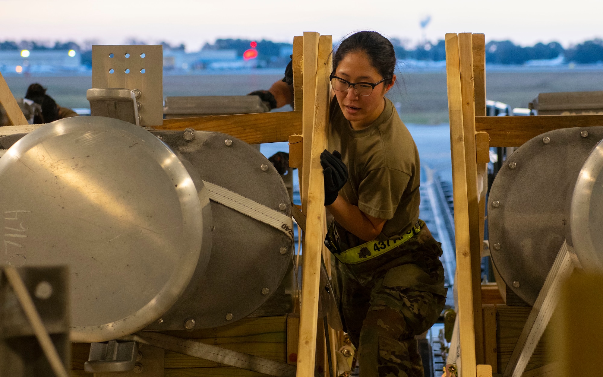 A photo of an Airman pushing cargo onto a C-17.