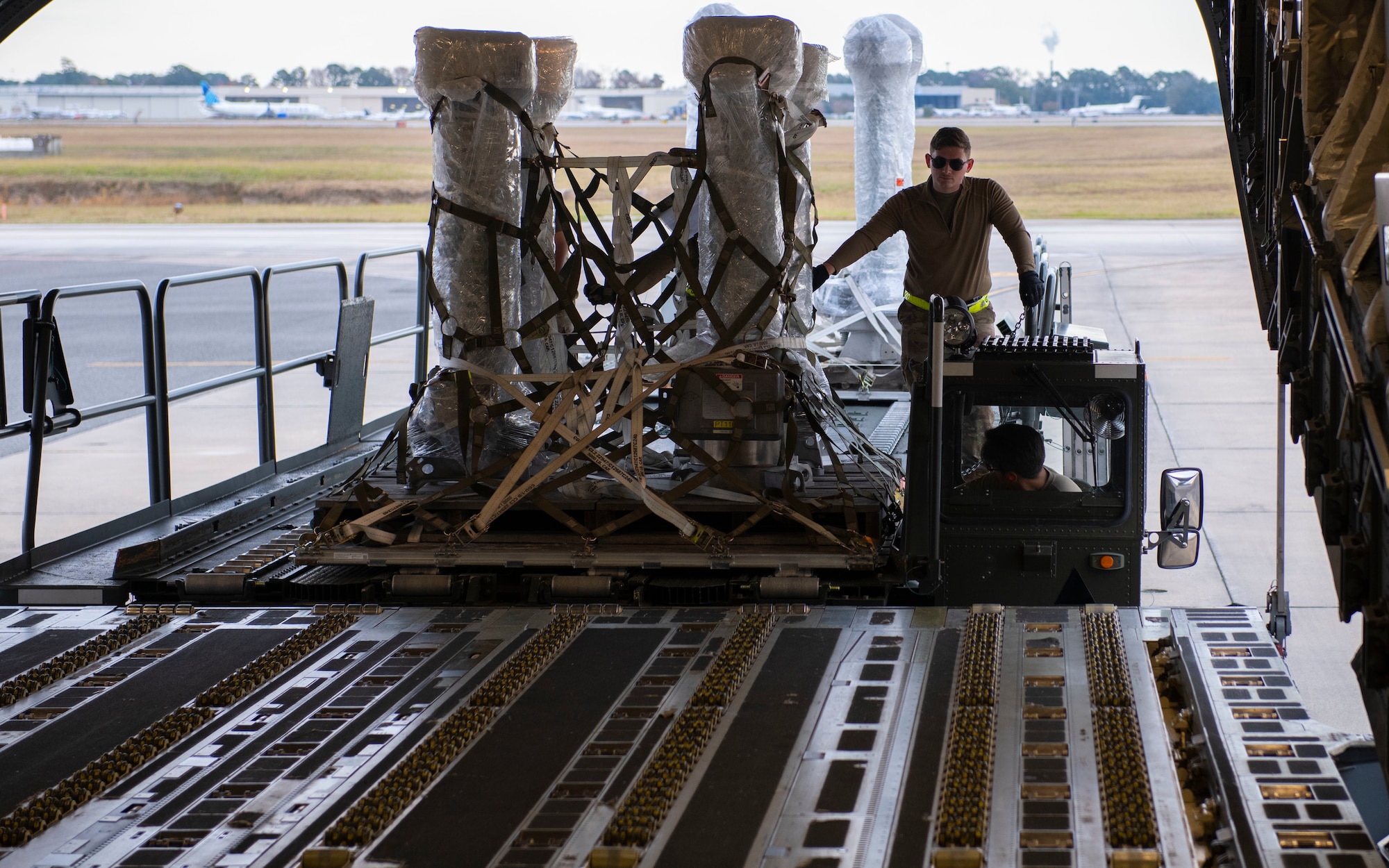 A photo of an Airman loading cargo on a C-17.