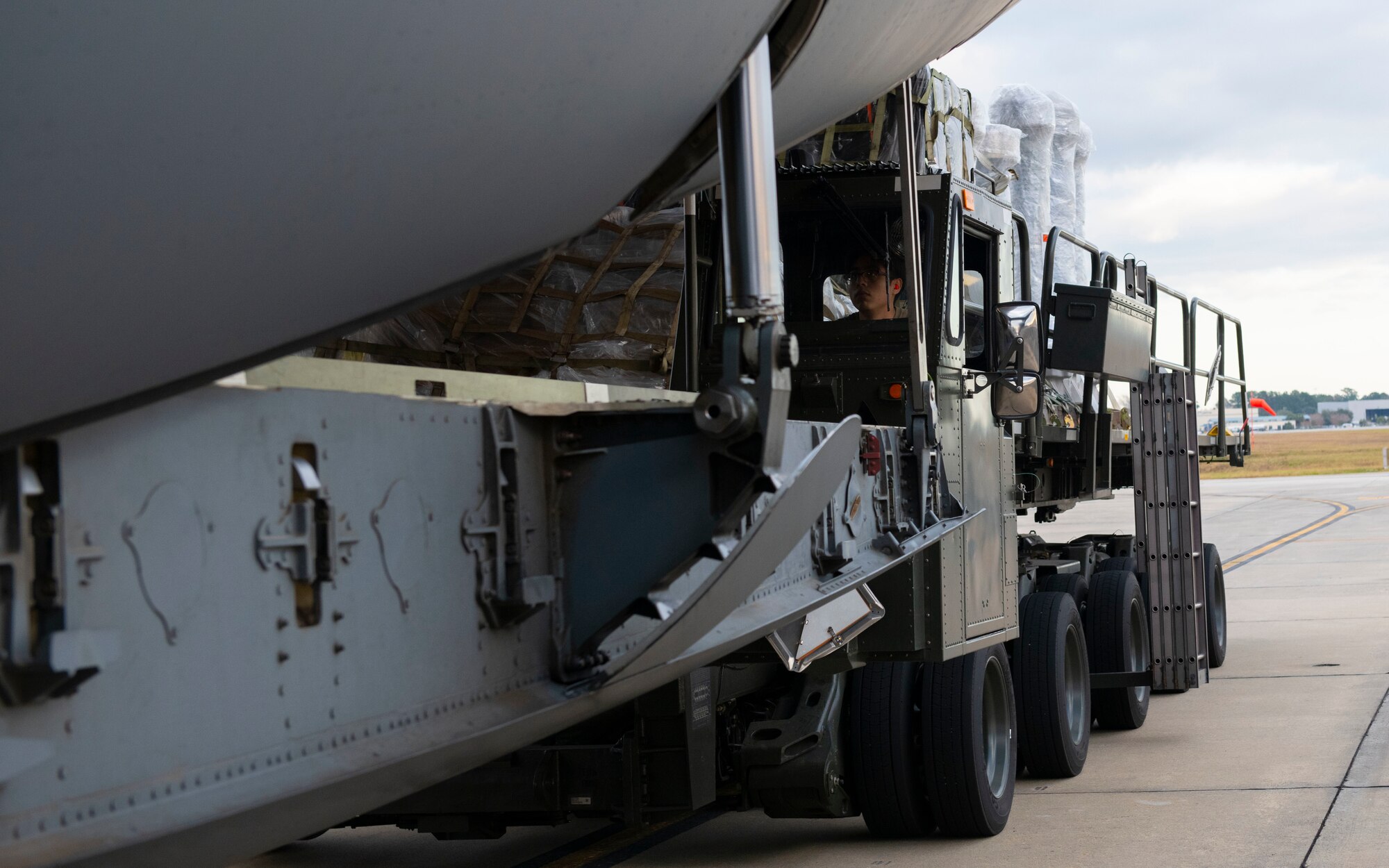 A photo of an Airman loading cargo on a C-17.