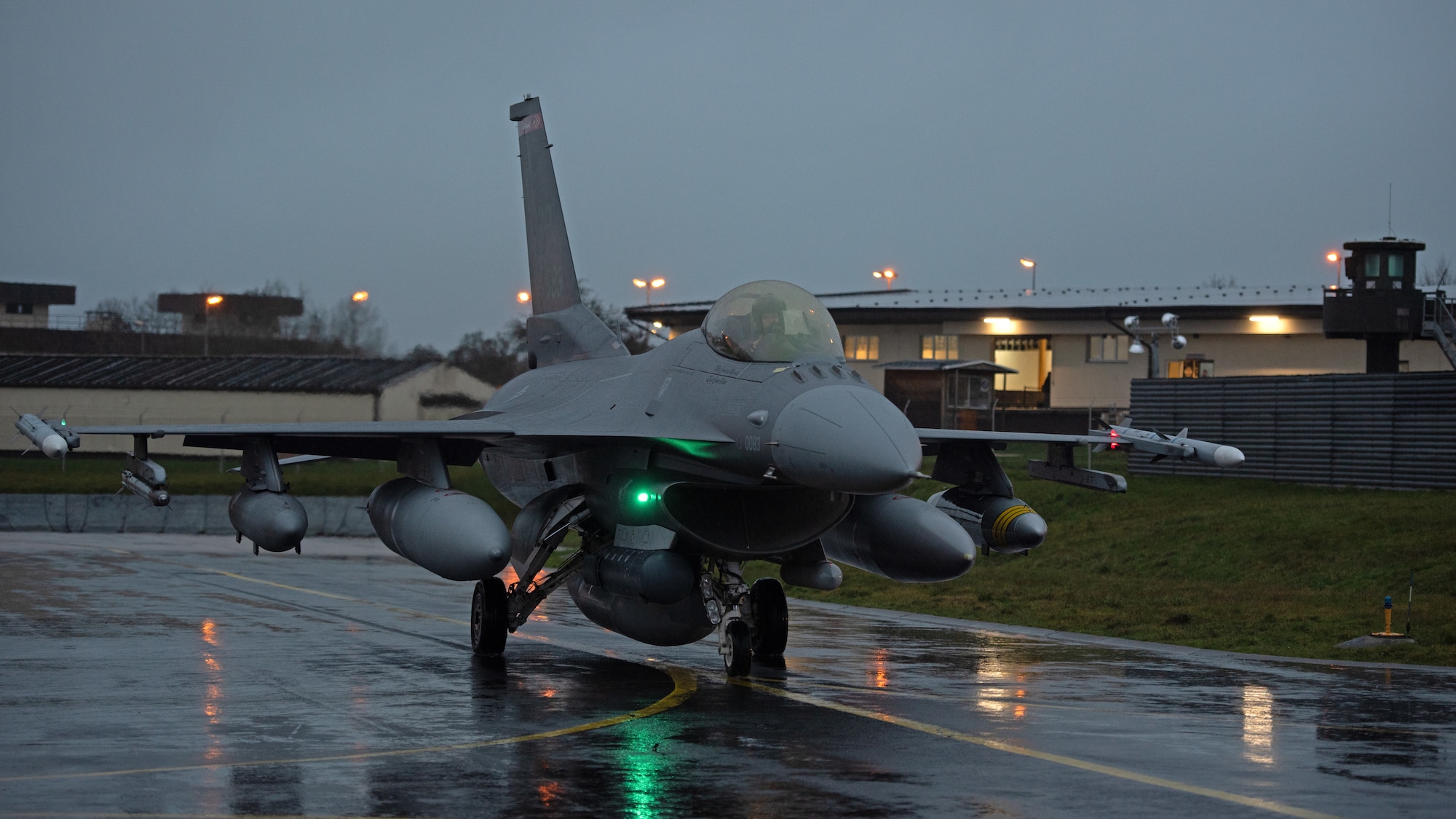 An F-16 taxis in the rain.