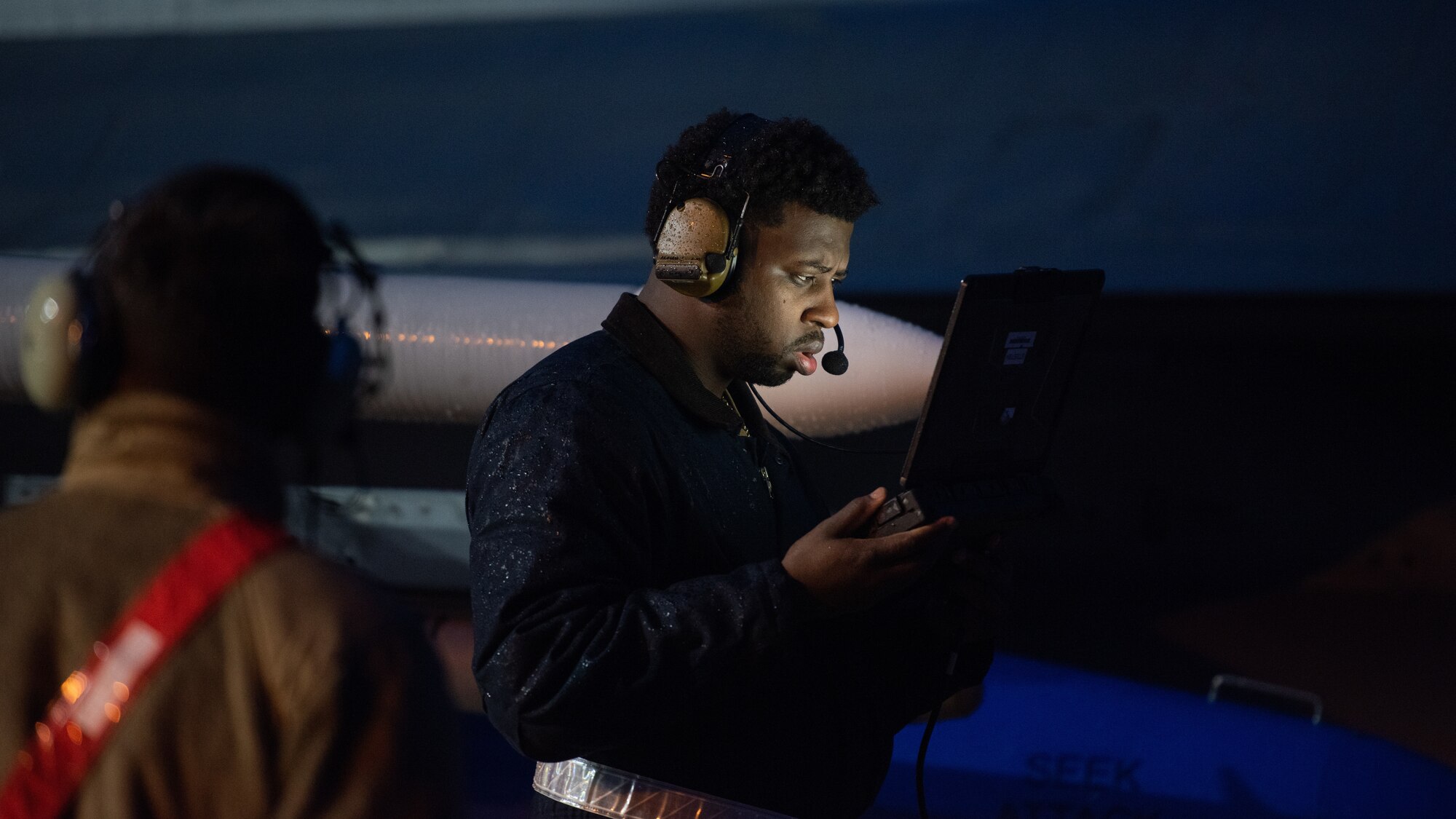 An Airman works on a computer on the flightline.