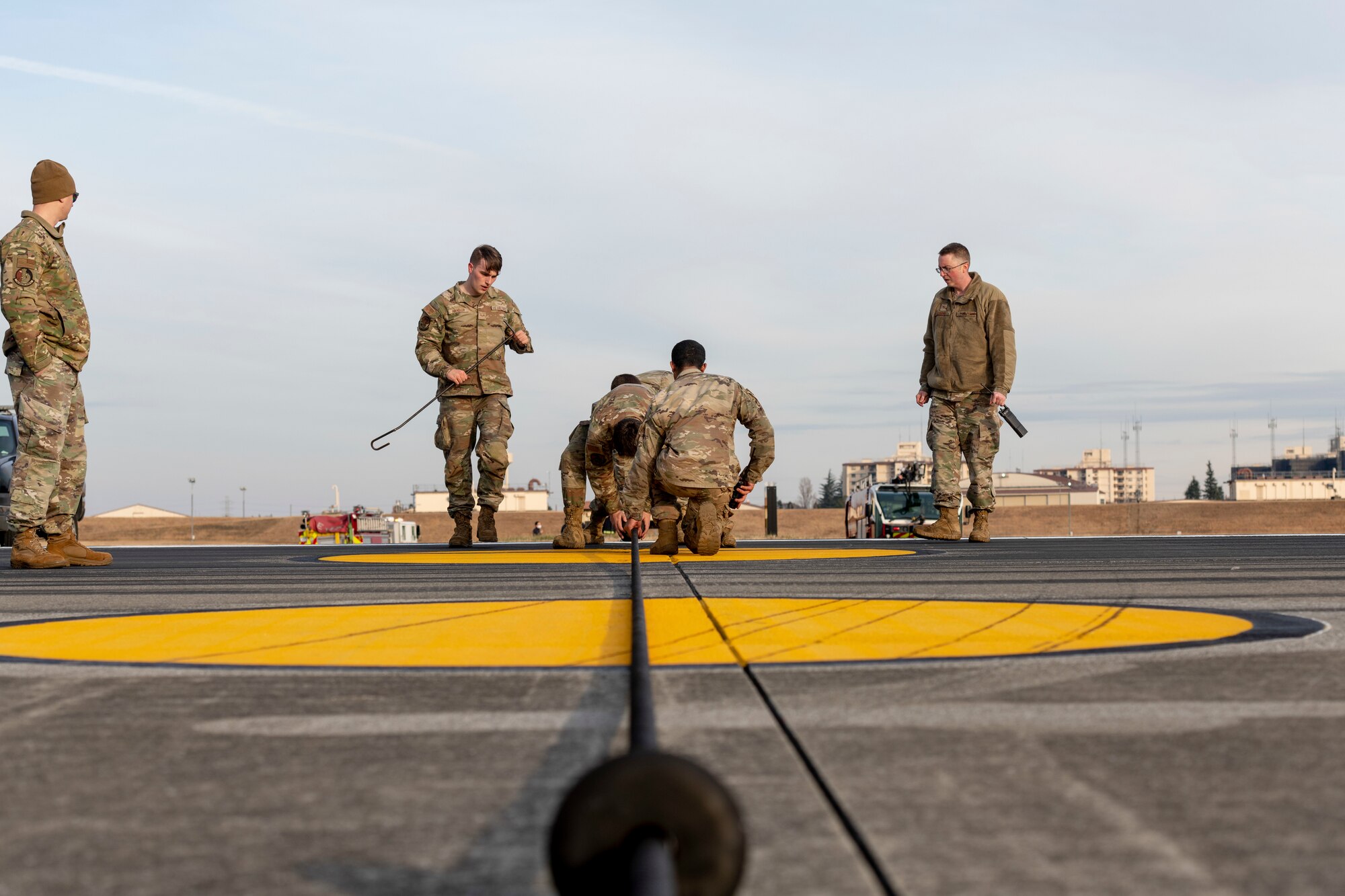 Airmen from the 374th Civil Engineer Squadron power production shop ensure the flightline Aircraft Arresting System (AAS) is set up properly for an annual certification test at Yokota Air Base, Japan, Jan. 6, 2023.