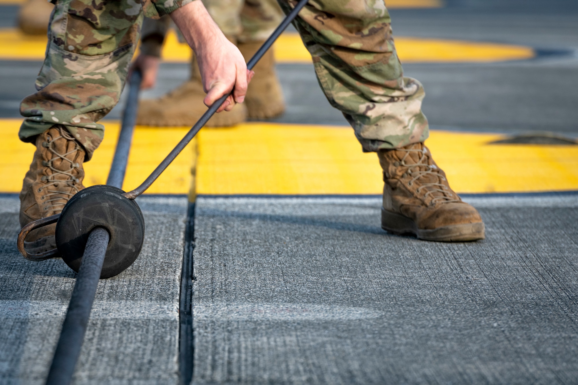 Senior Airman Jacob Handler, 374th Civil Engineer Squadron power production journeyman, ensures precise spacing in-between cable donuts prior to the annual certification test of the Aircraft Arresting System (AAS) at Yokota Air Base, Japan, Jan. 6, 2023.
