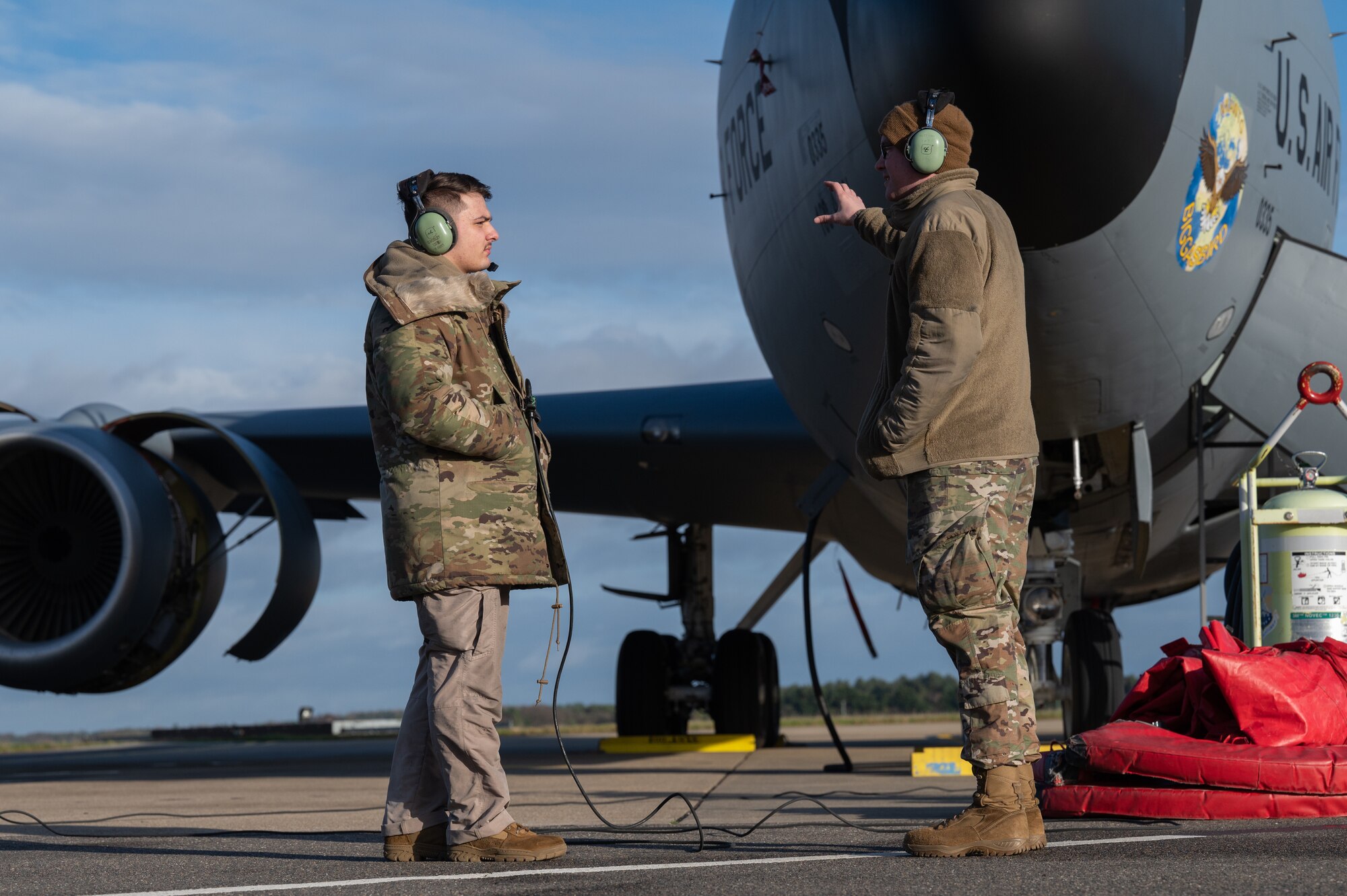 U.S. Air Force Airman 1st Class Cole Barkley, left, 100th Aircraft Maintenance Squadron aerospace propulsion apprentice, and Staff Sgt. Guy Mobley, right, 100th AMXS aerospace propulsion craftsman, discuss KC-135 Stratotanker aircraft idle engine run procedures, Jan. 9, 2023, at Royal Air Force Mildenhall, England.