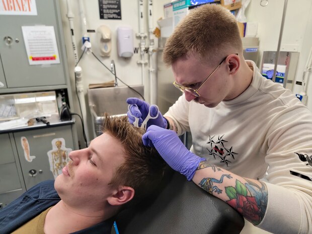 230110-N-KU796-1001 PHILIPPINE SEA (Jan. 10, 2023) U.S. Navy Hospital Corpsman 3rd Class Jesse Turner, from Grand Terrace, Calif., removes medical staples aboard the aircraft carrier USS Nimitz (CVN 68). Nimitz is in 7th Fleet conducting routine operations. 7th Fleet is the U.S. Navy's largest forward-deployed numbered fleet, and routinely interacts and operates with Allies and partners in preserving a free and open Indo-Pacific region. (U.S. Navy photo by Mass Communication Specialist 2nd Class Samuel Osborn)