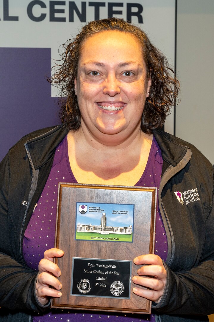 Dorit Wodaege-Wells shows the plaque she received after being named the 2022 Senior Civilian of the Year – Clinical/Direct Care during the January Director's Town Hall Meeting held, Jan. 10, 2023 in Clark Auditorium at Walter Reed National Military Medical Center (WRNMMC), Bethesda Maryland.