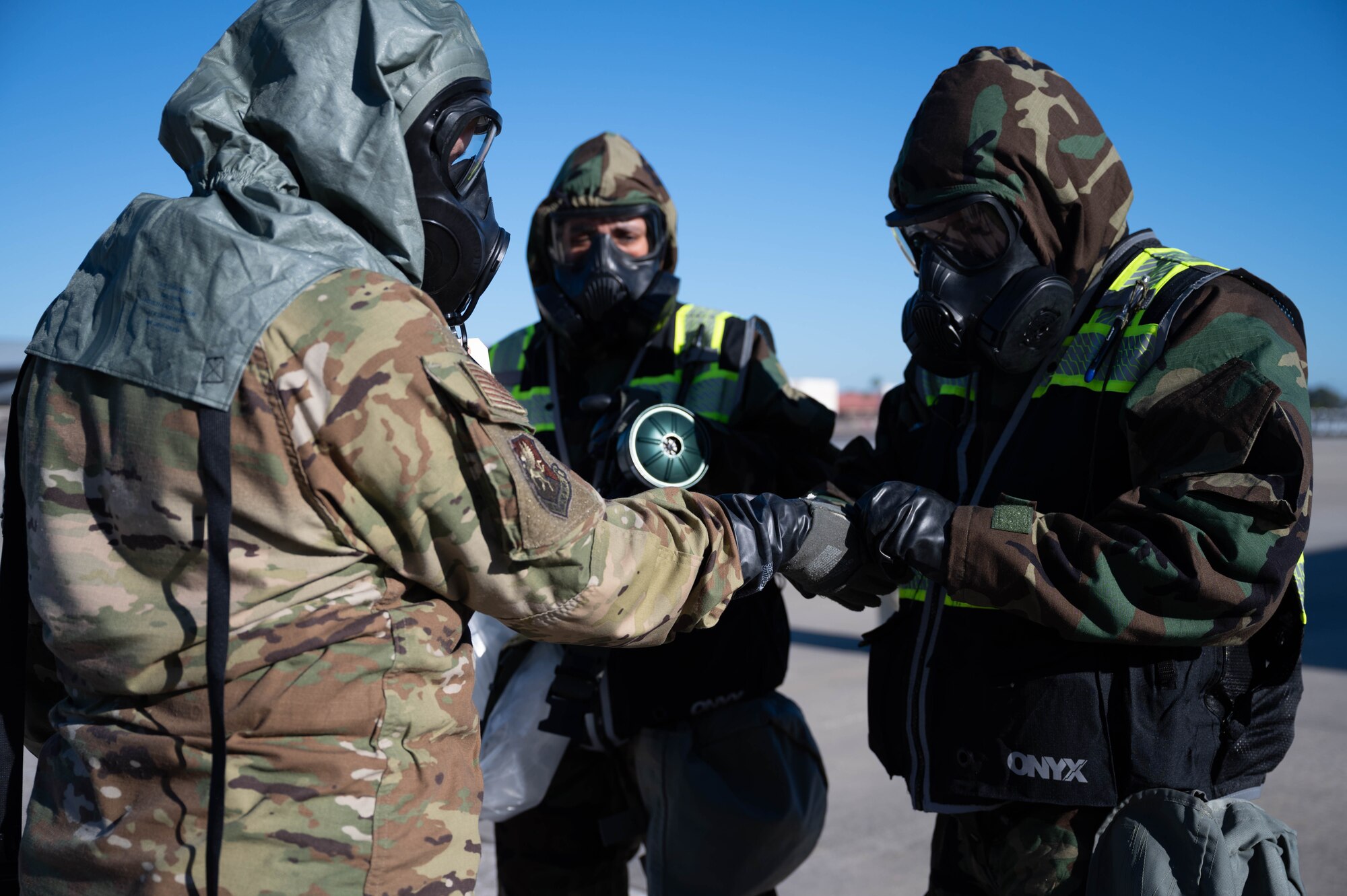 Citizen Airmen from the 927th Air Refueling Wing, MacDill Air Force Base, Fla., simulate removing contaminated equipment and clothing in a decontamination line Jan. 8, 2023. Maintaining readiness is a top priority during the unit training assembly weekends for Reserve Airmen at the 927th ARW. (U.S. Air Force photo by Staff Sgt. Alexis Suarez)