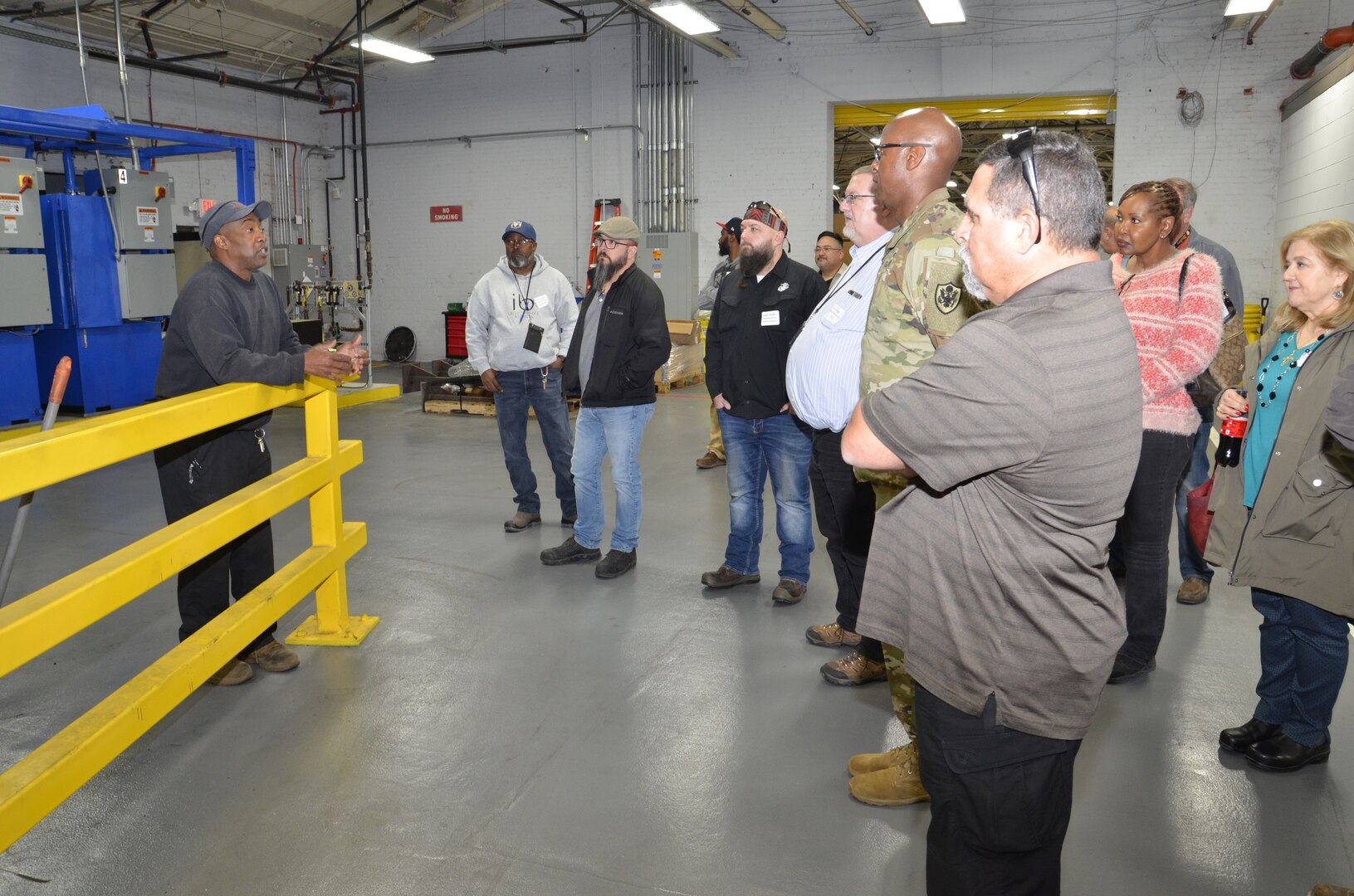 group listening to man speak in a warehouse