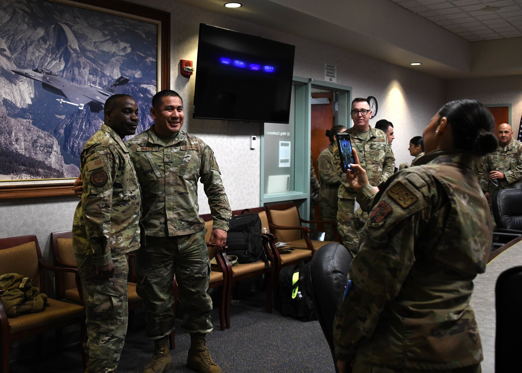 Two men, both wearing green camouflage uniforms, pose together for a photo together.