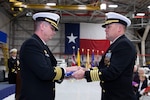 Capt. James Ward (right), Deputy Commodore of Commander, Fleet Logistics Support Wing (CFLSW), presents an American flag to outgoing CFLSW Capt. Ian Hawley (right) during Hawley's retirement ceremony in the Fleet Logistics Support Wing (VR) 59 hangar at Naval Air Station (NAS) Joint Reserve Base (JRB) Fort Worth. CFLSW is a Naval Air Force Reserve wing, comprised of 11 fleet logistics squadrons, providing the Navy’s sole organic intra-theater airlift capability operating worldwide. (U.S. Navy photo by Chief Mass Communication Specialist Chelsea Milburn)