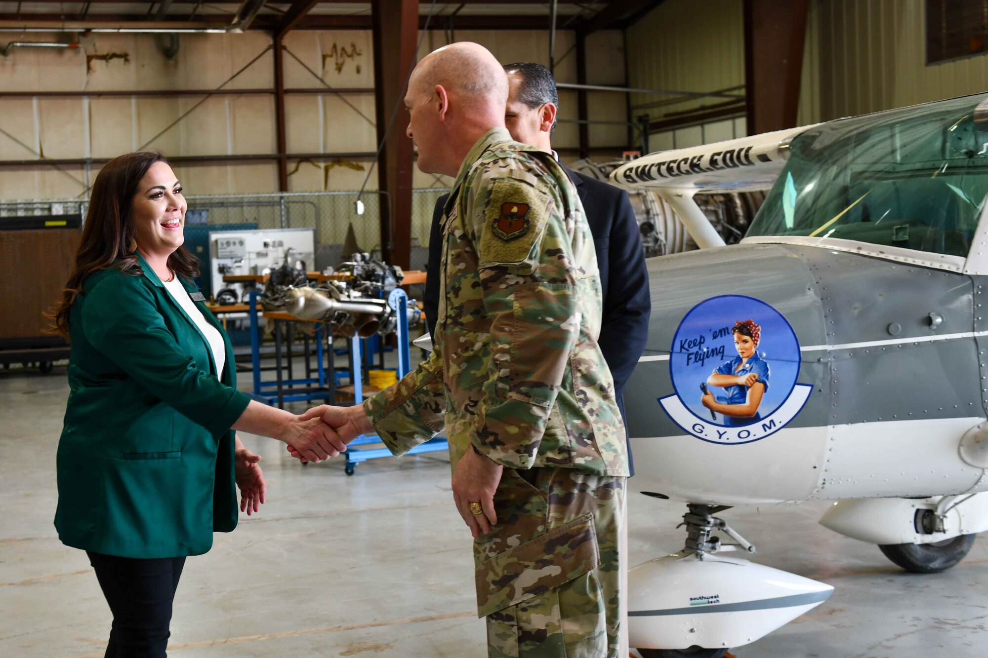 Col. Blaine Baker, 97th Air Mobility Wing commander coins Jill Lazenby, Southwest Technology Center, at Hangar 33 in Altus, Oklahoma on Jan. 11, 2023. Baker coined several members of SWTC leadership who put together the luncheon and tour for AAFB service members. (U.S. Air Force photo by Airman 1st Class Kari Degraffenreed)