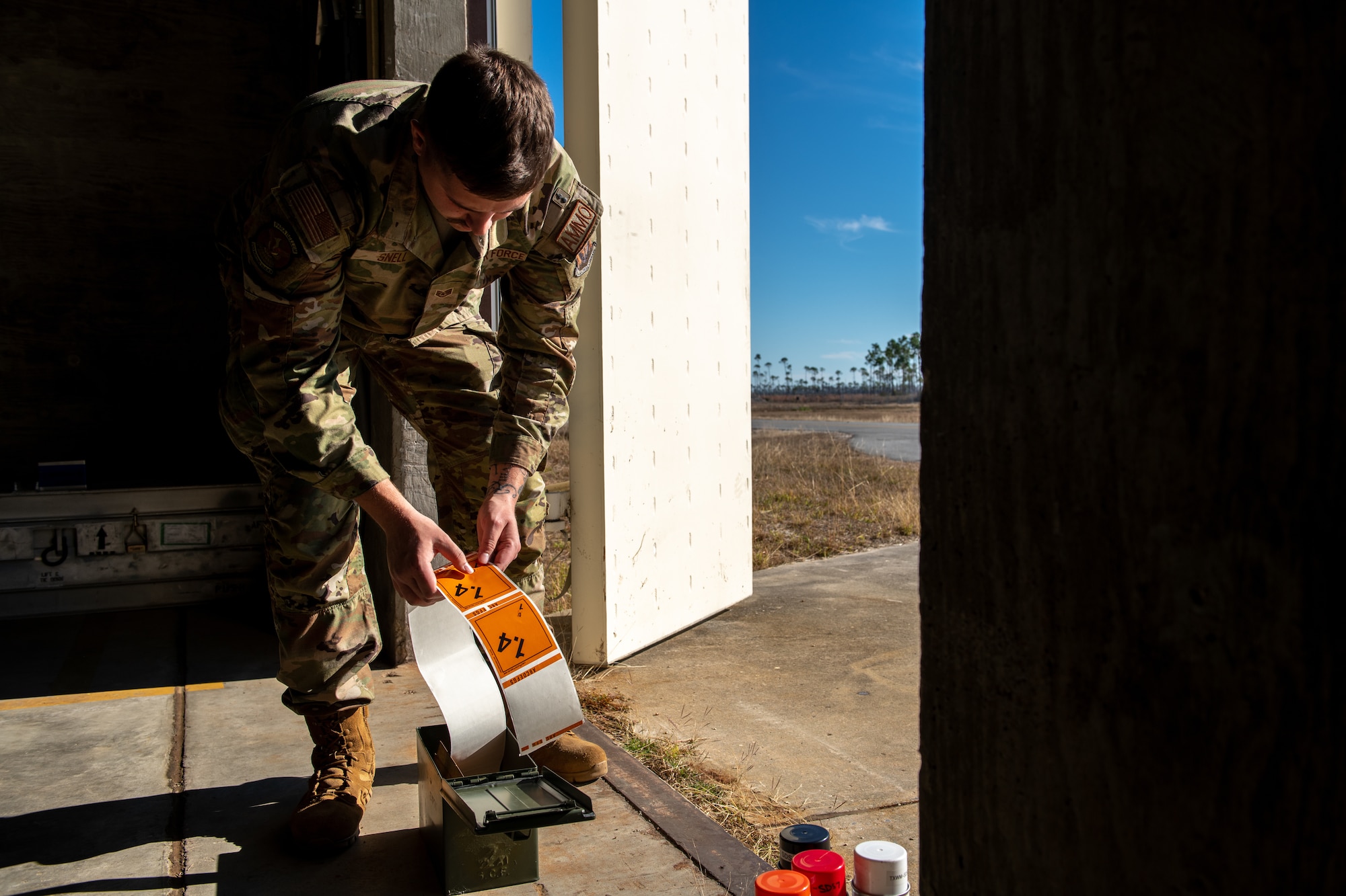 An airmen peels a sticker for an explosive container