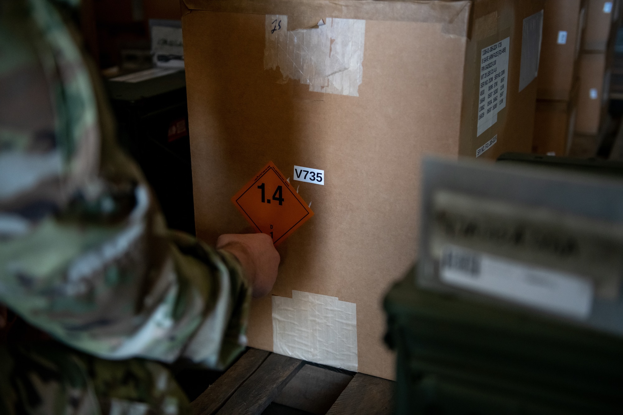 An airmen places a sticker on an explosive box