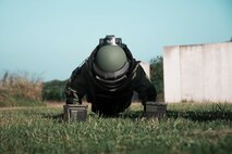 U.S. Marine Corps Cpl. Triston Gilpin, communications and navigation systems technician, Marine Aviation Logistics Squadron 24, conducts the pushups during the bomb suit agility test as part of the Explosive Ordinance Disposal screening process, Marine Corps Base Hawaii, Jan. 10, 2023. The purpose of the event was to demonstrate EOD’s capabilities, test the capabilities of the Marines participating in the screening, and recruit new members.(U.S. Marine Corps photo by Lance Cpl. Terry Stennett III)
