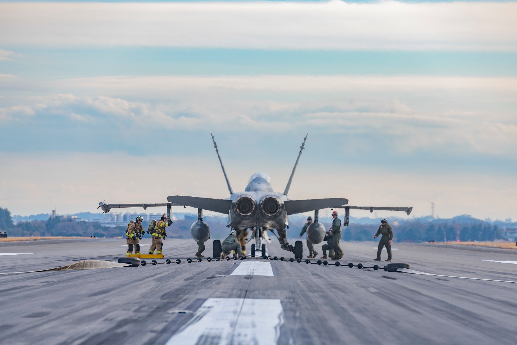 U.S. Marine maintenance crew members deployed to Marine Corps Air Station Iwakuni, detach a U.S. Marine Corps F/A-18C Hornet from an Aircraft Arresting System cable before performing an inspection during an annual certification at Yokota Air Base, Japan, Jan. 6, 2023.