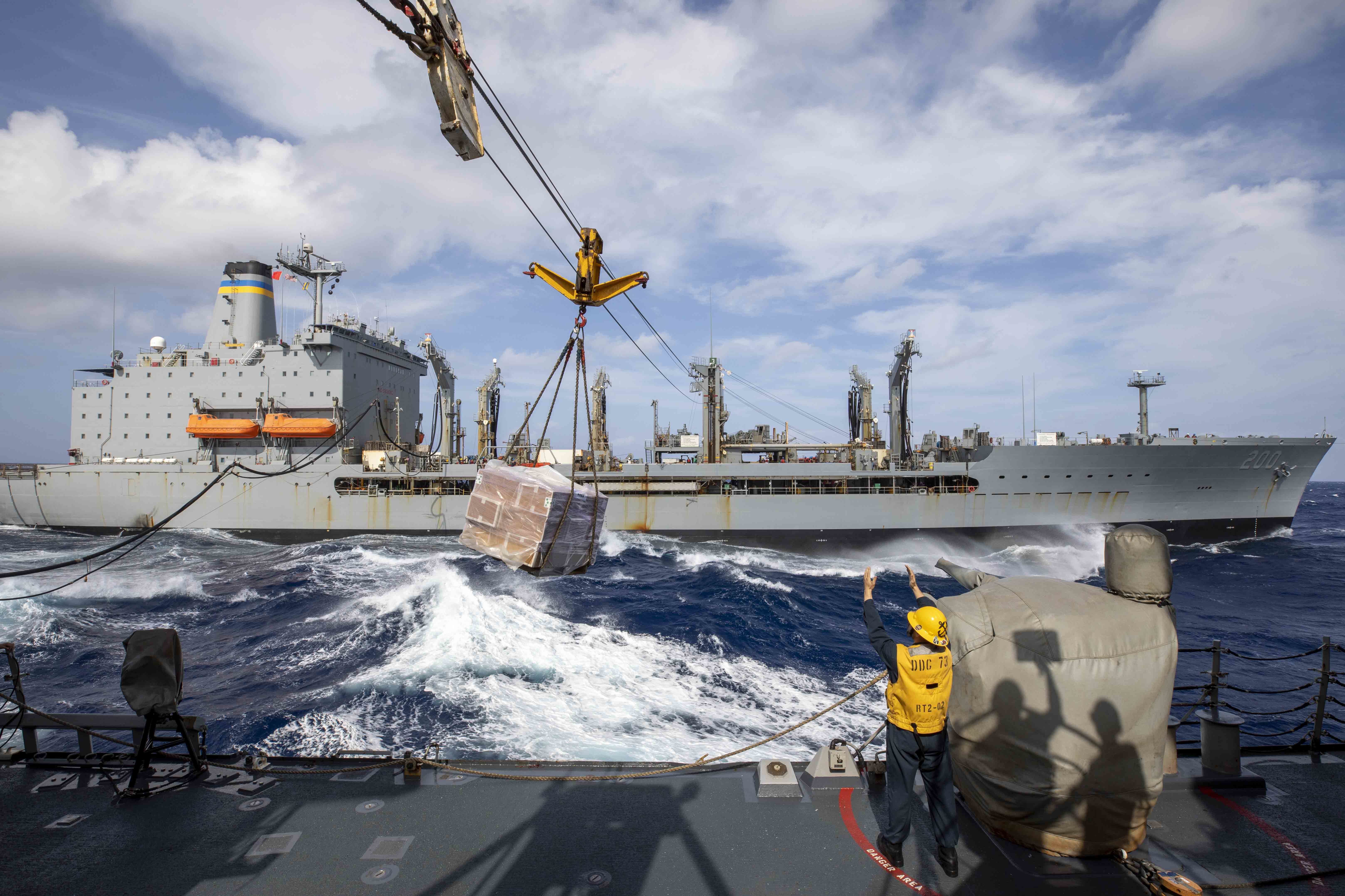 U.S. Navy Boatswain’s Mate 3rd Class Keaton Lester, from Wichita Falls, Texas, signals to the fleet replenishment oiler USNS Guadalupe (T-AO 200) during a replenishment-at-sea (RAS) aboard the Arleigh Burke-class guided-missile destroyer USS Decatur (DDG 73), Jan. 11, 2023.