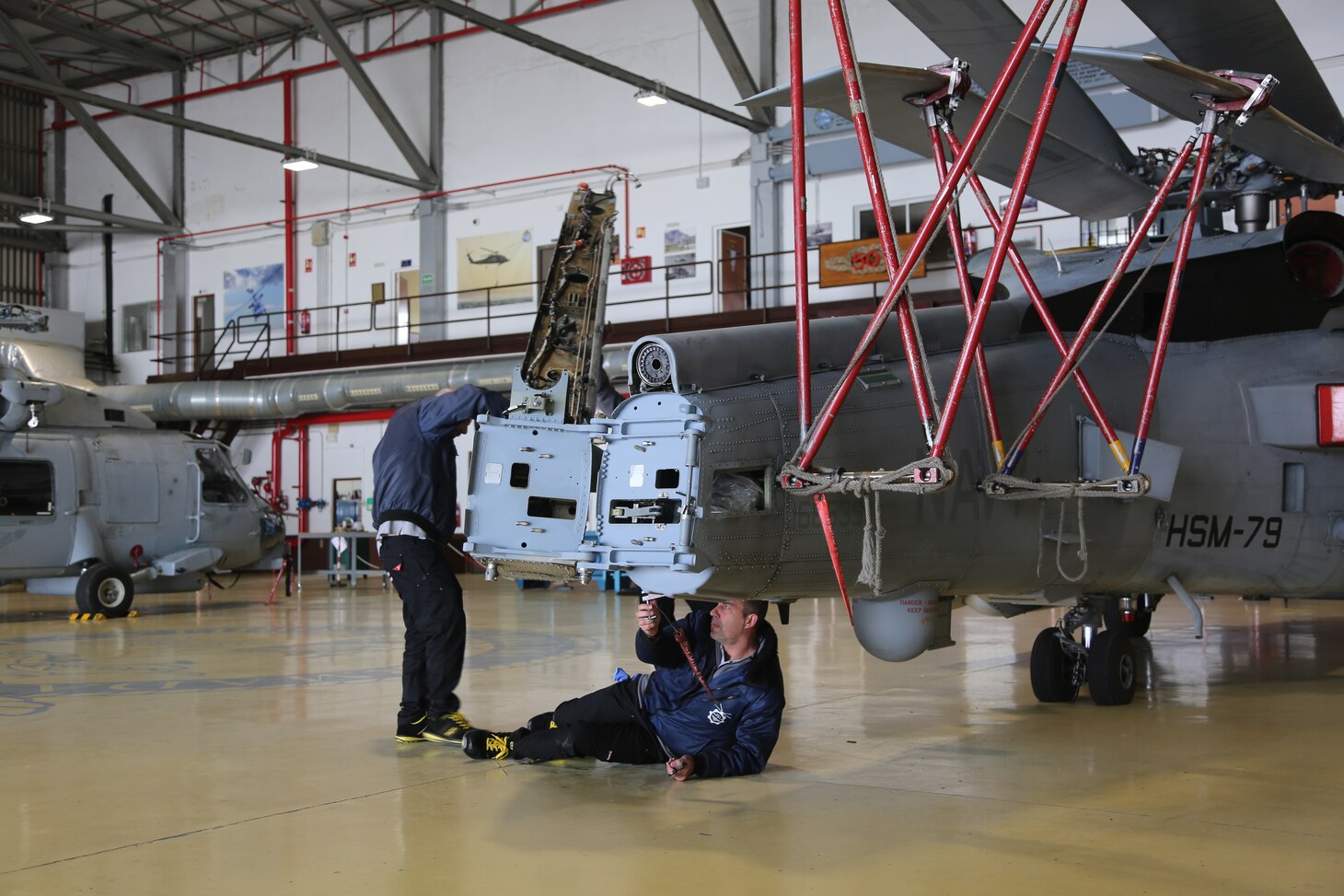 Craftsman work on tail of a helicopter.