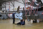 Craftsman work on tail of a helicopter.