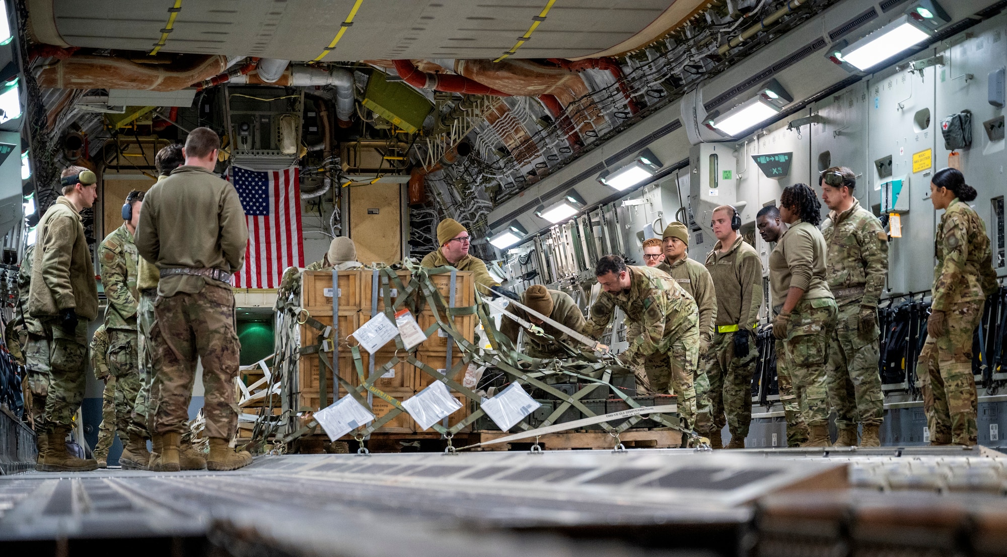 U.S. Air Force Airmen from the 386th Expeditionary Logistics Readiness Squadron push a palette of supplies off a C-17 Globemaster III