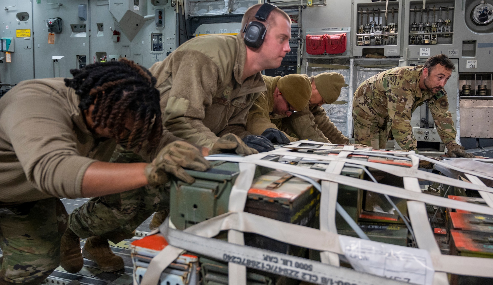 U.S. Air Force Airmen from the 386th Expeditionary Logistics Readiness Squadron push a palette of supplies off a C-17 Globemaster III
