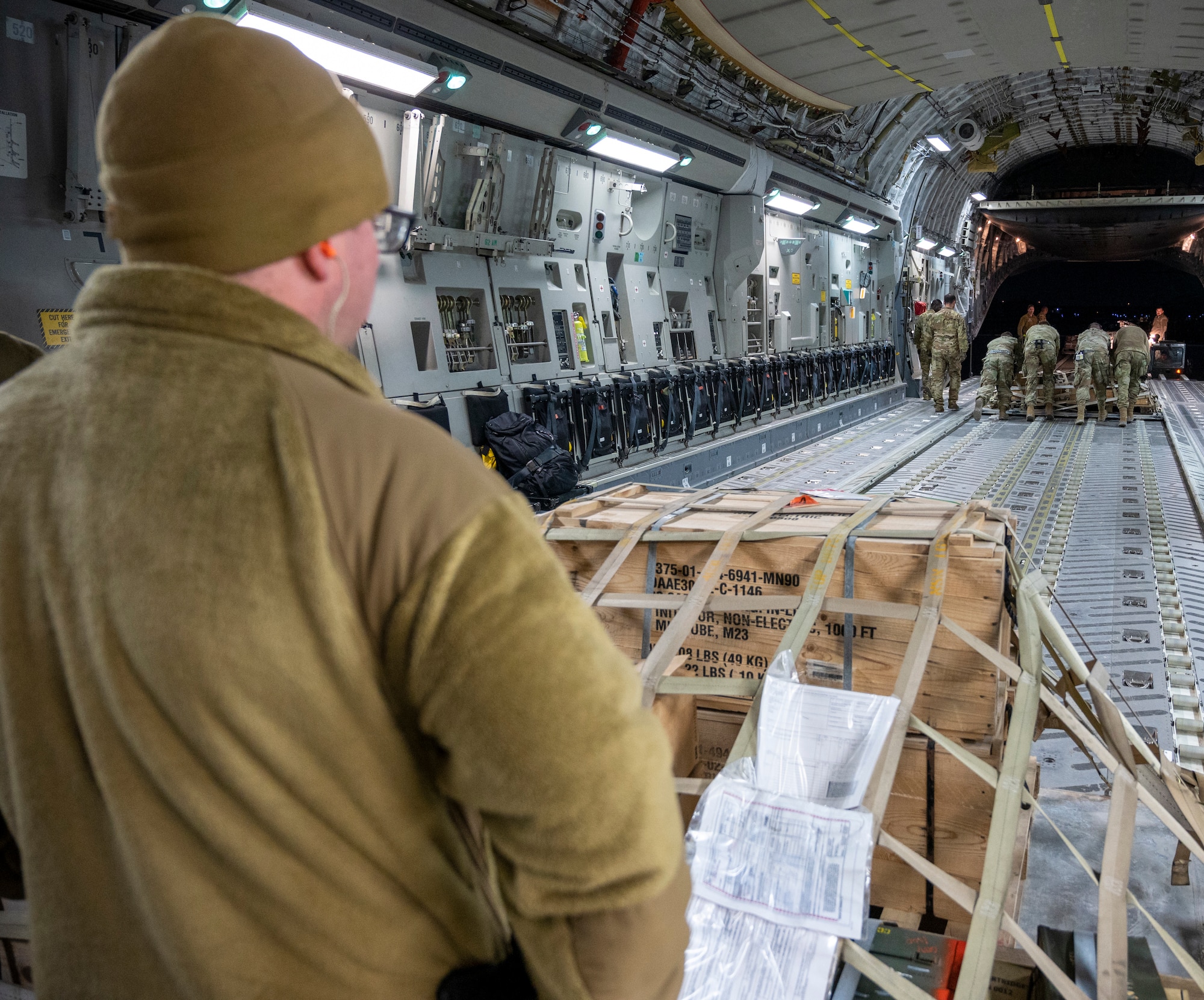U.S. Air Force Airmen from the 386th Expeditionary Logistics Readiness Squadron push a palette of supplies off a C-17 Globemaster III.