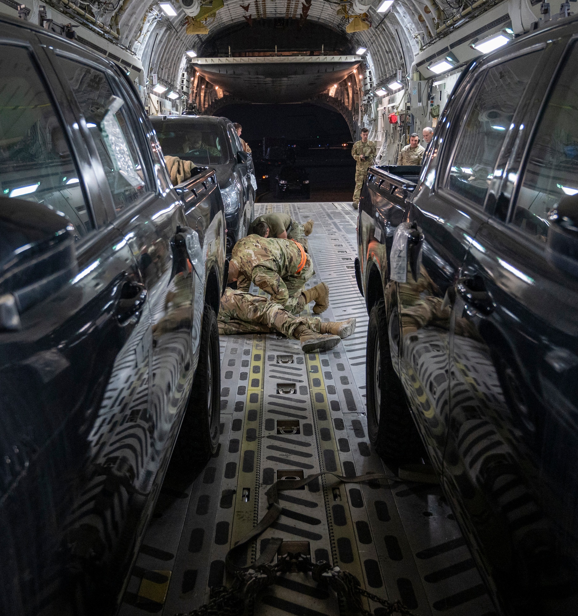 U.S. Air Force Airmen from the 386th Logistics Readiness Squadron secure a compact pick-up truck on a C-17 Globemaster III