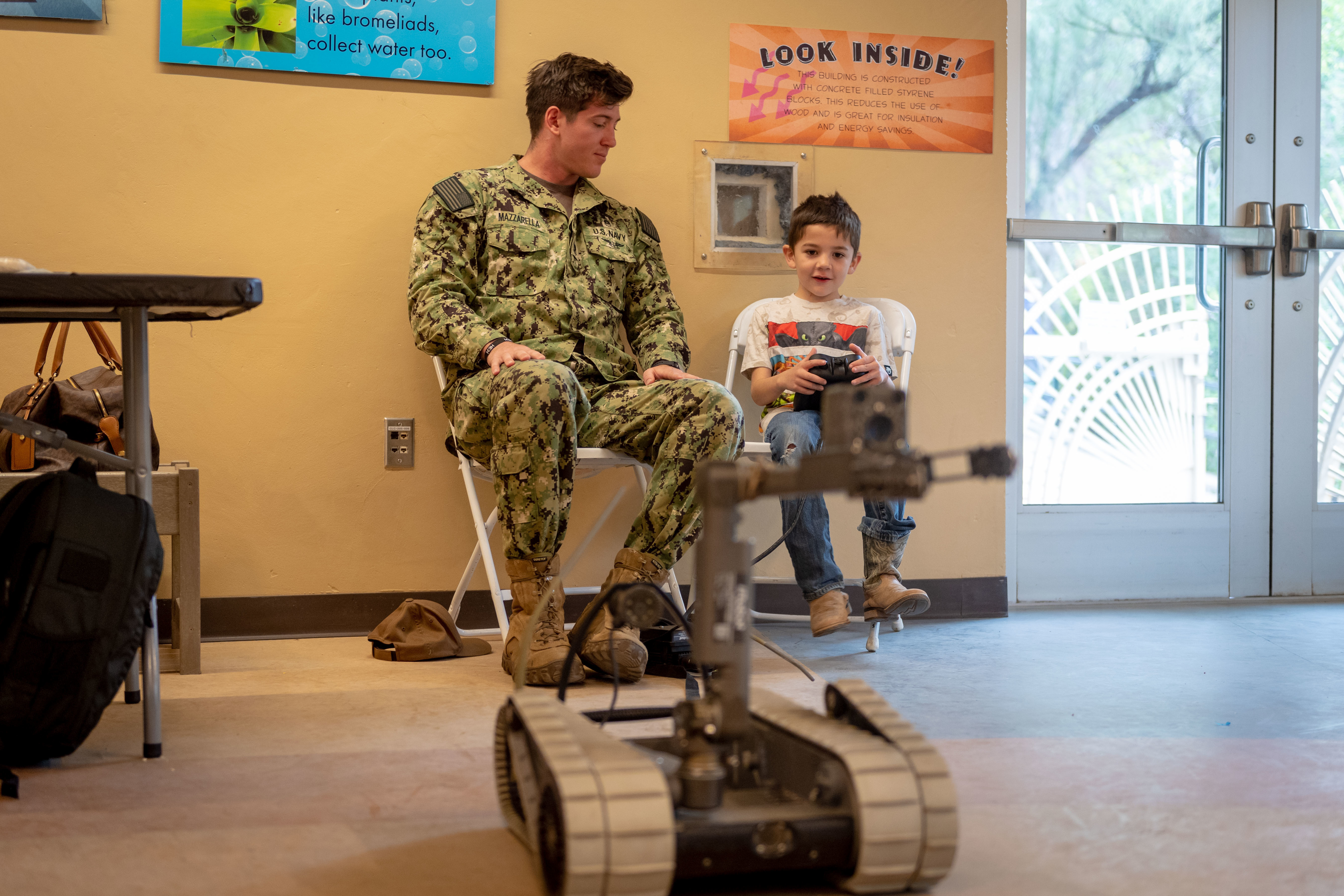 Navy Diver 2nd Class Alan Mazzarella shows a child how to operate a bomb detecting robot during Tucson Navy Week