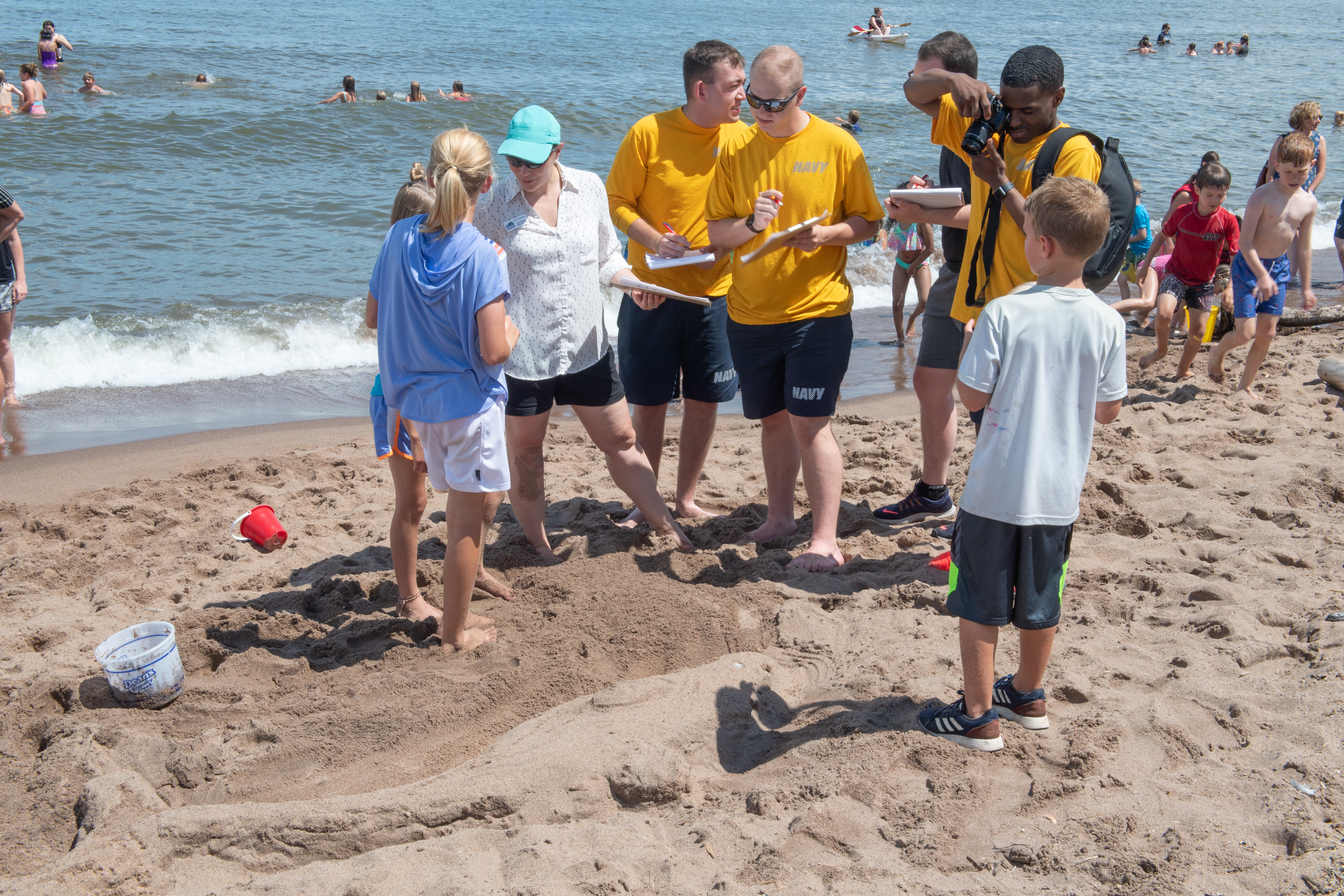 ailors assigned to Pre-Commissioning Unit (PCU) Minneapolis-Saint Paul (LCS 21) judge sand sculptures at the Park Point Sand Modeling Contest as part of Duluth Navy Week, July 18