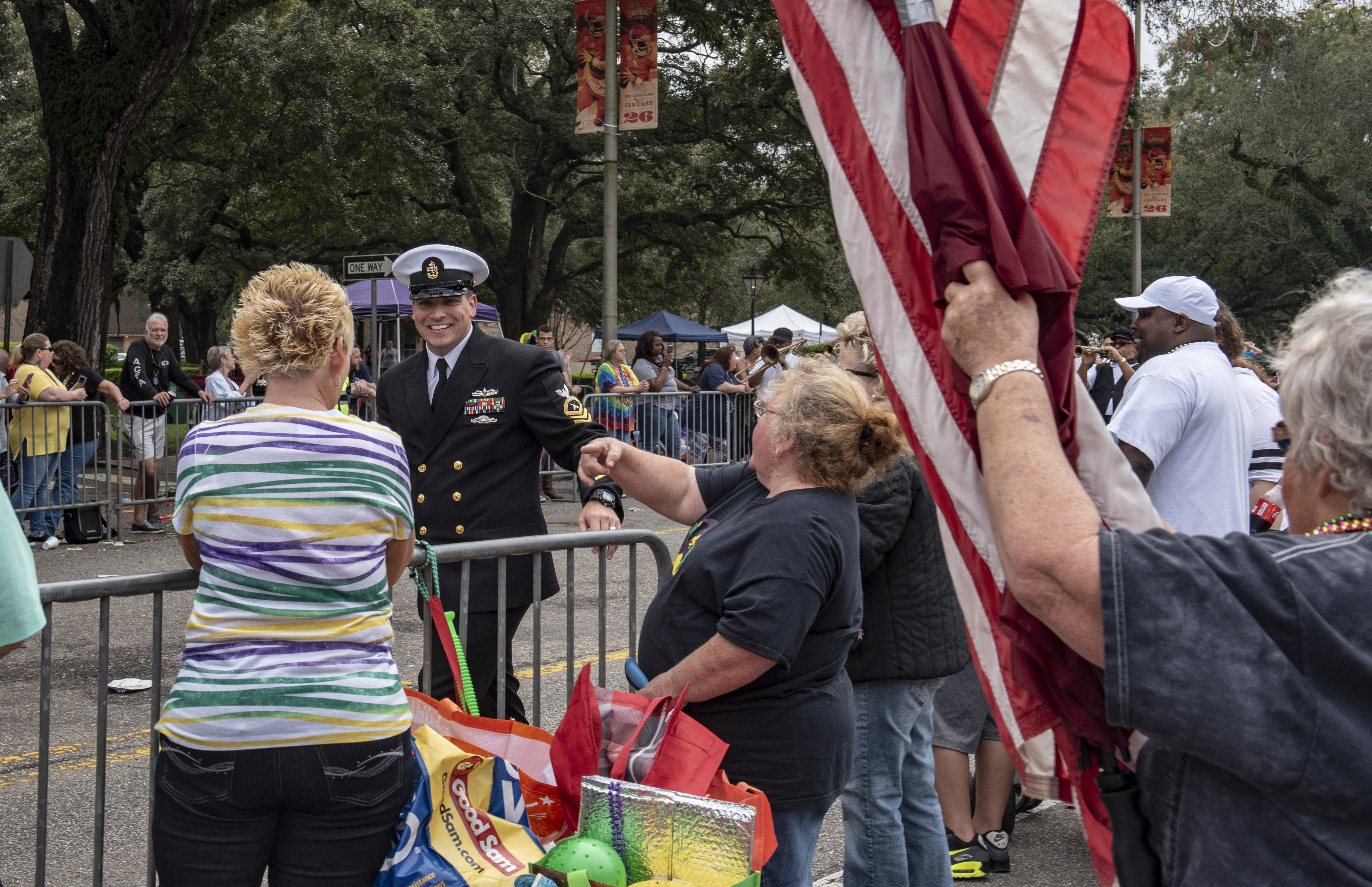 Chief Gunner's Mate Michael Kerley, from St. Louis, Mo., interacts with the crowd at the Floral Parade, which takes place as part of the Mardi Gras festivities in Mobile, Alabama.