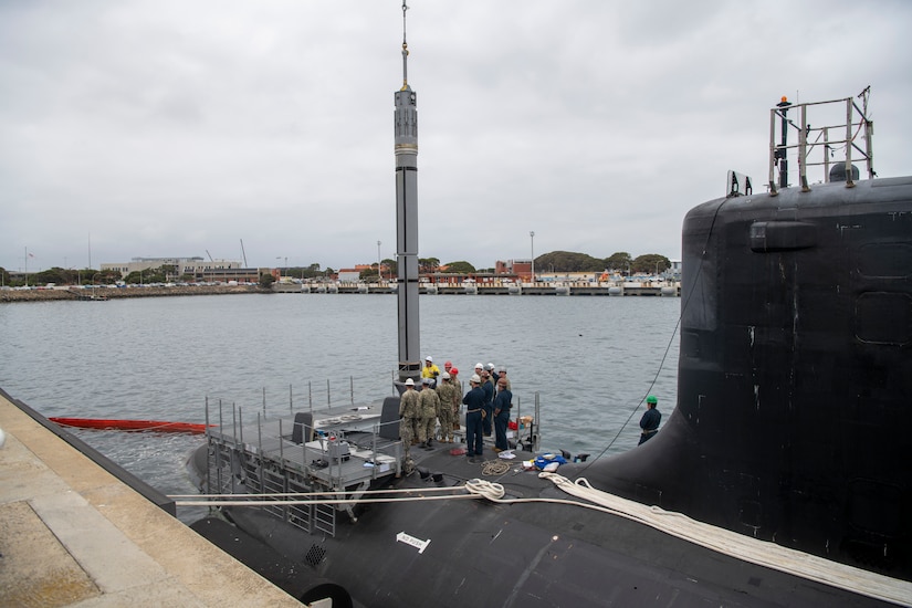 U.S. and Australian sailors stand on a submarine.