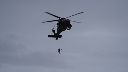 Alaska Army Guard Spc. Matthew Tucker, a flight medic assigned to Golf Company, Detachment 2, 2-211th General Support Aviation Battalion, is lowered via hoist from an Alaska Army National Guard HH-60M Black Hawk helicopter at Camp Mad Bull on Joint Base Elmendorf-Richardson, Alaska, Jan. 10, 2023. Army Guard aircrews conducted aerial insertion, medical evacuation and hoist operations with Special Tactics Airmen assigned to 24th Special Operations Wing, Detachment 1.