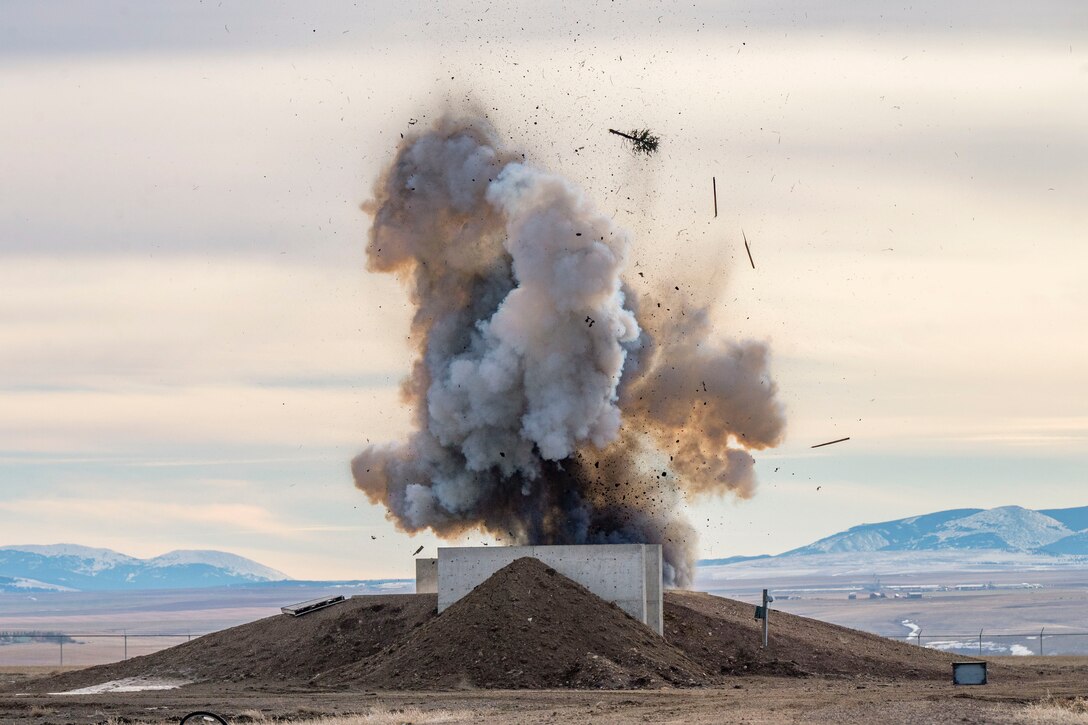 Smoke rises in the air as a Christmas tree is blown up near mountains.