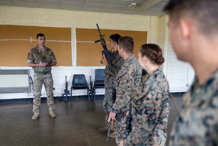 British Royal Marine Cpl. Charlie Walker, a GD training corporal with 43 Commando Fleet Protection Group Royal Marines, conducts a weapon familiarization test for U.S. Marines with Marine Corps Security Force Regiment on the C8 assault rifle during Tartan Eagle phase II, Otterburn Training Camp, Europe, Oct. 24, 2022. U.S. Marines must properly handle the Royal Marines primary weapon system to pass the annual combat marksmanship training test while overseas with 43 Cdo RM. Exercise Tartan Eagle is an annual bilateral training exercise for the U.S. Marines and British Royal Marines with 43 Cdo RM to travel to each command’s training facilities to exchange tactics, techniques and procedures in fixed site security.