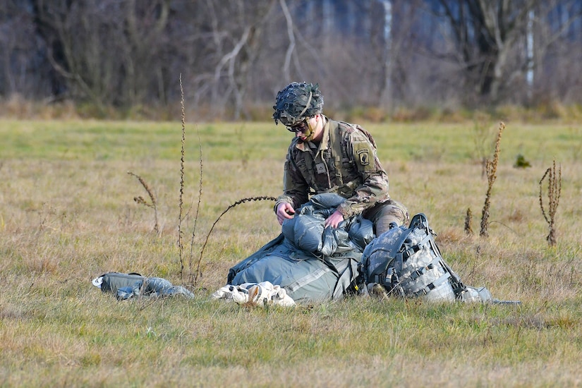 A paratrooper recovers his parachute.