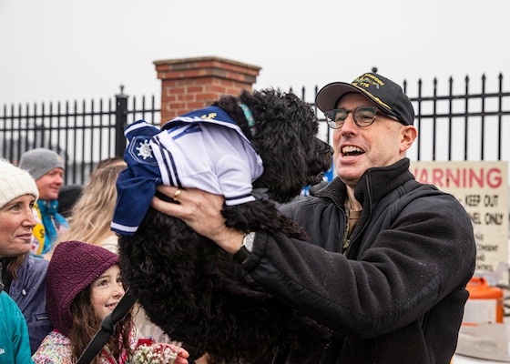 Capt. Bennett Christman greets his dog during a homecoming celebration for USS New Hampshire (SSN 778) at Naval Station Norfolk.